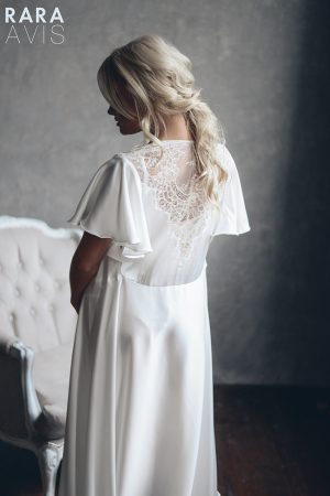 A bride wearing a white satin wedding robe Kalmer with lace back by rara avis