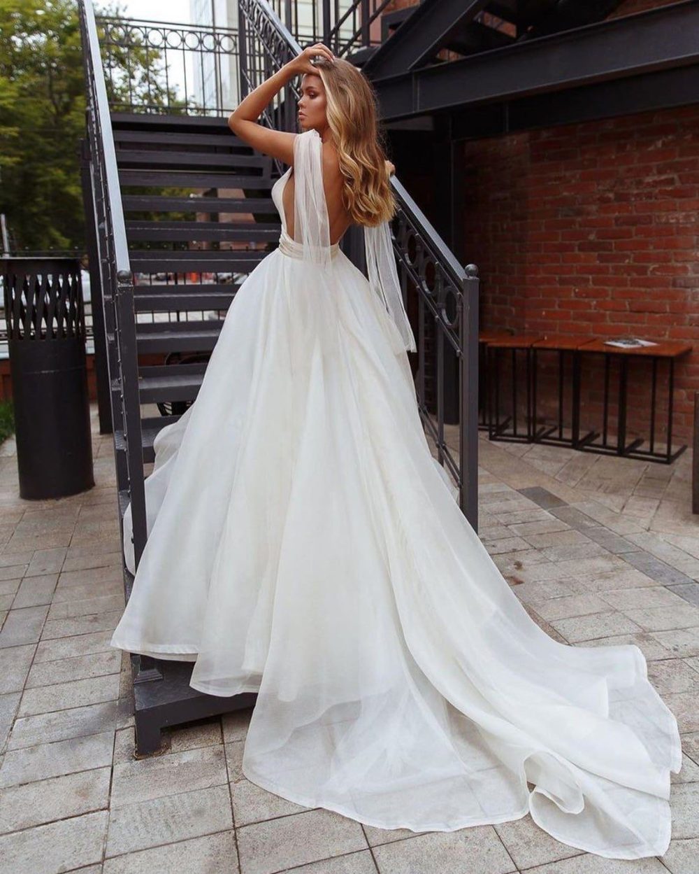 Bride wears white a-line style dress Elba by Rara Avis with wings and deep cut neckline, image 3