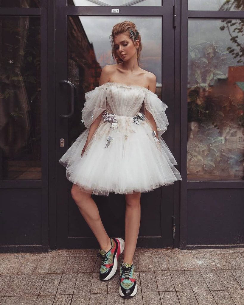 A bride wearing comfortable running shoes with her short mini dress