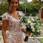 Dell'Amore bride wears bridal dress Velari and holds a bridal bouquette